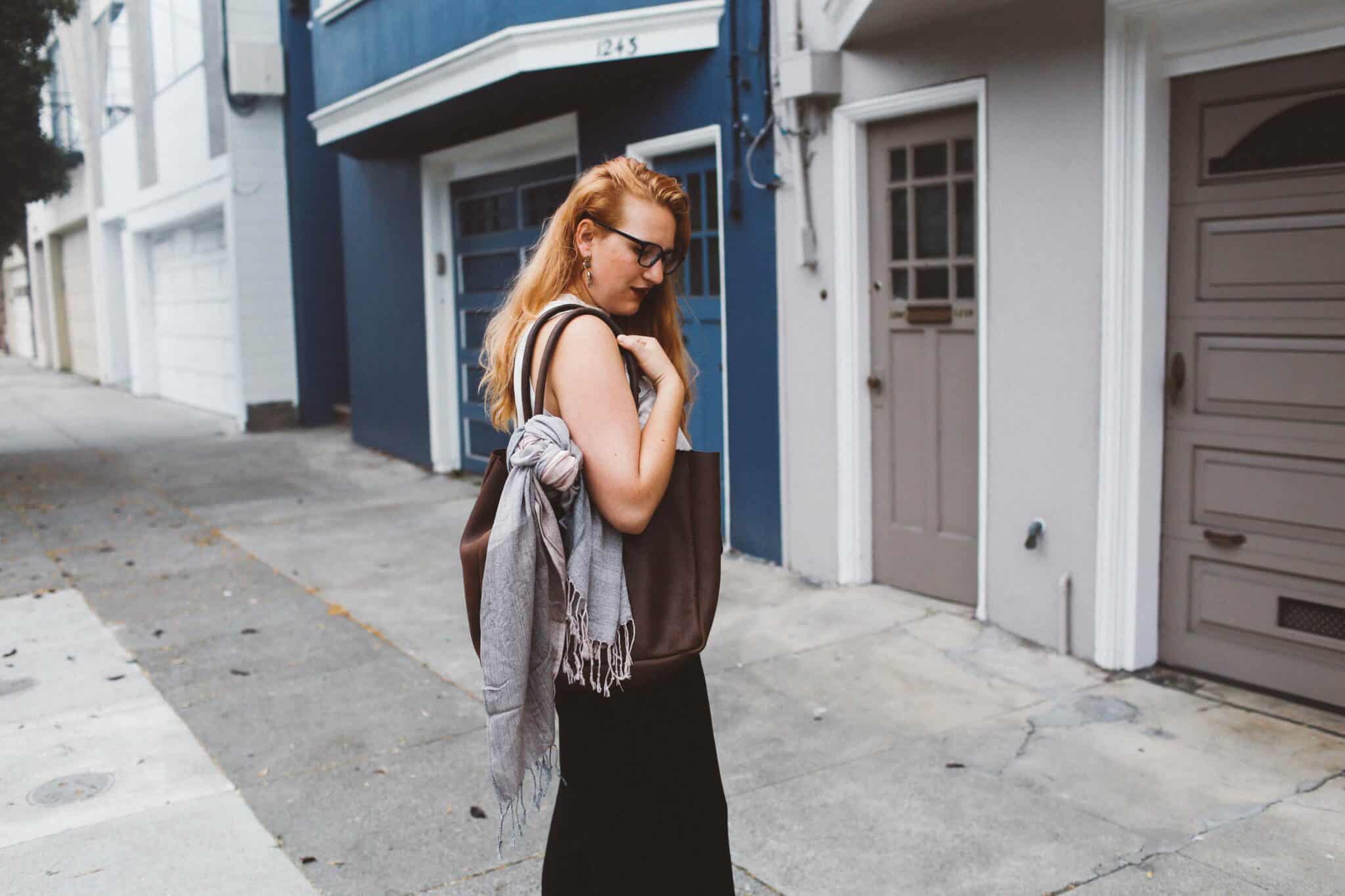 pink scarf black wide leg pants woman red hair leather tote bag