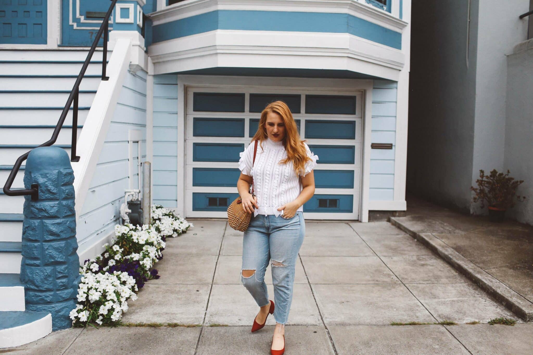 red heels wicker purse jeans white sweater bows