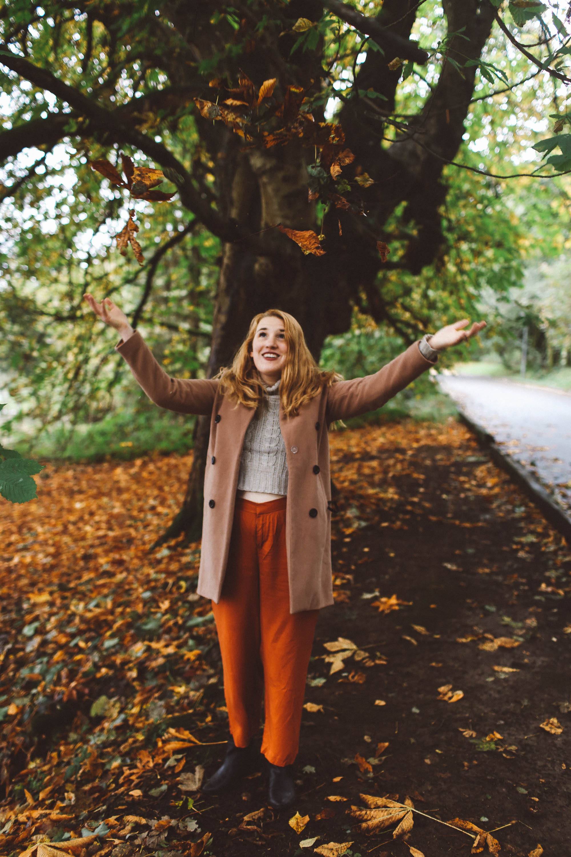 woman camel coat orange pants scotland outfit leaves