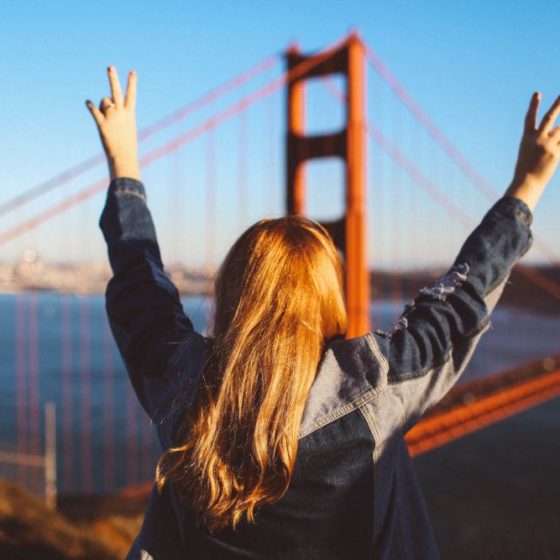 woman peace sign Golden Gate Bridge San Francisco