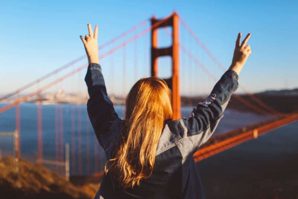 woman peace sign Golden Gate Bridge San Francisco