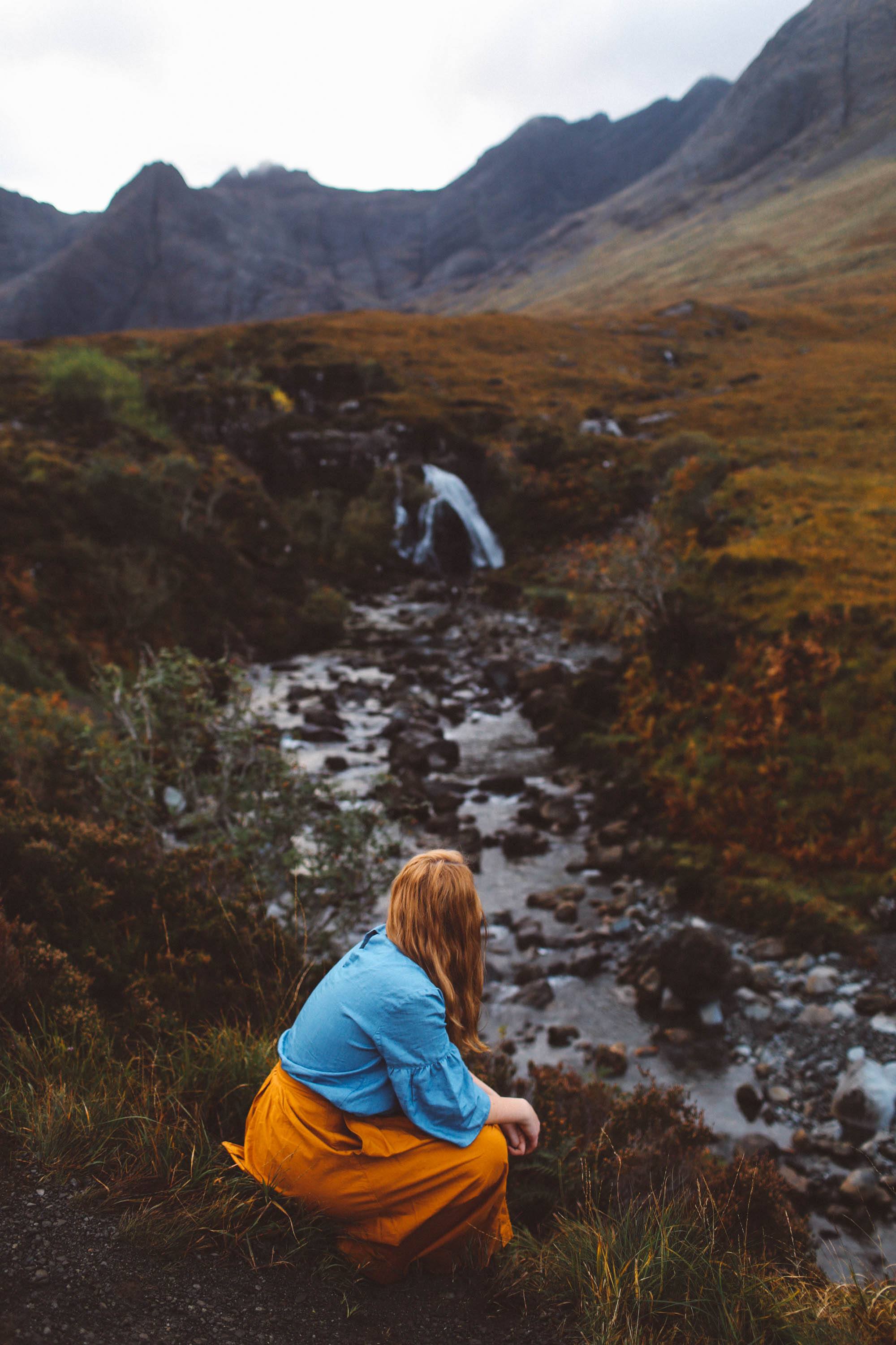 fairy pools isle of skye orange skirt woman