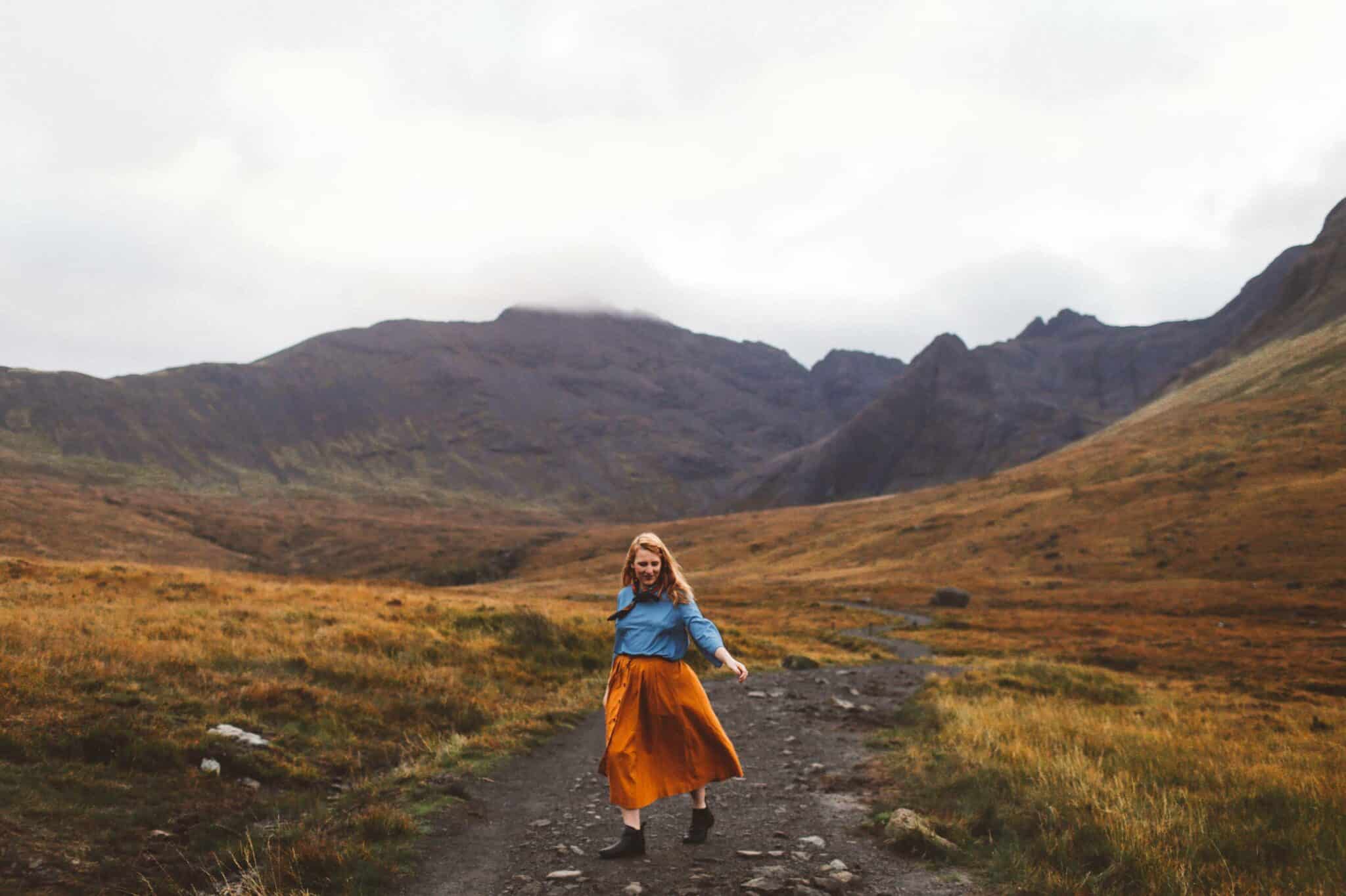 fairy pools isle of skye orange skirt woman