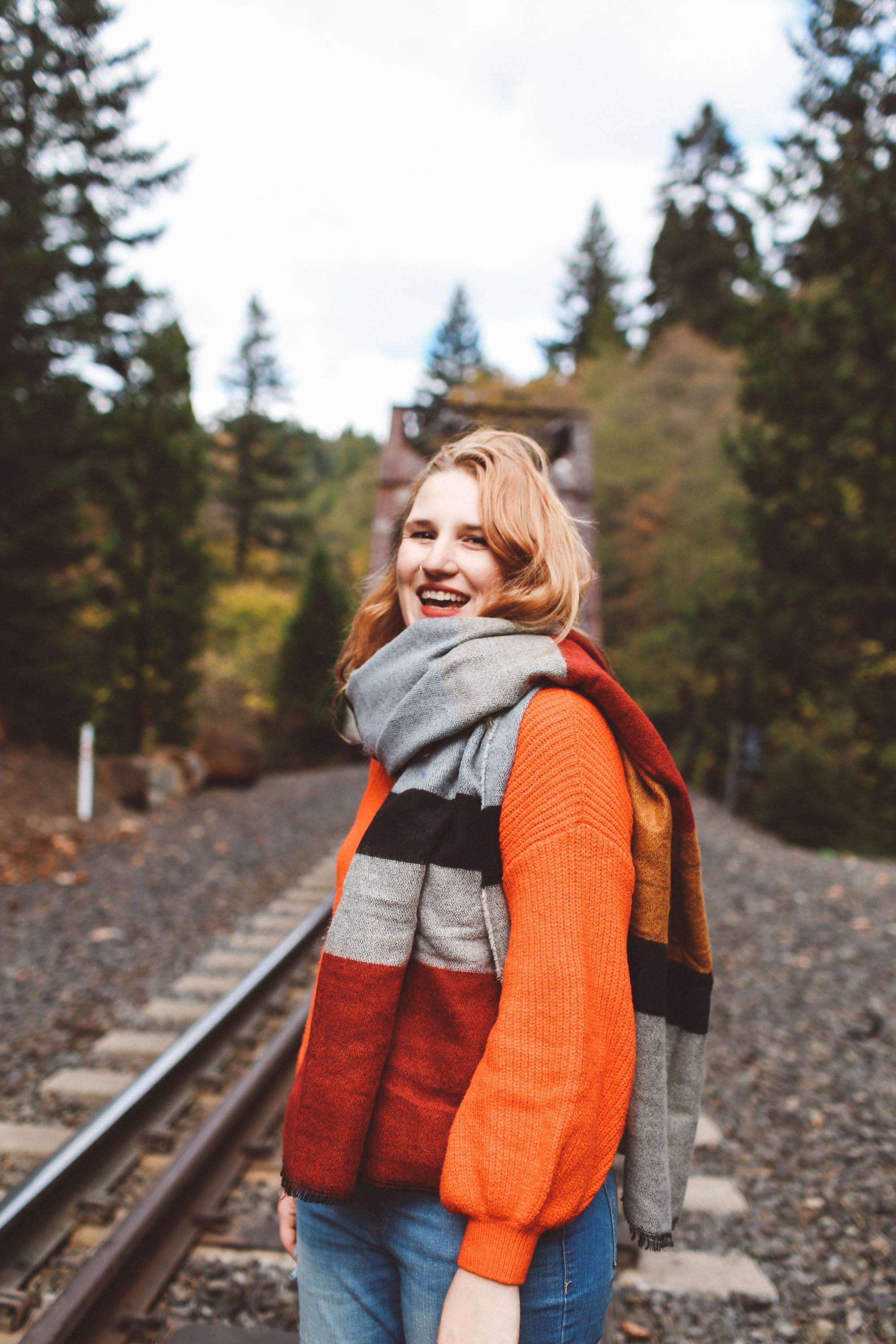 woman train tracks red sweater scarf fall