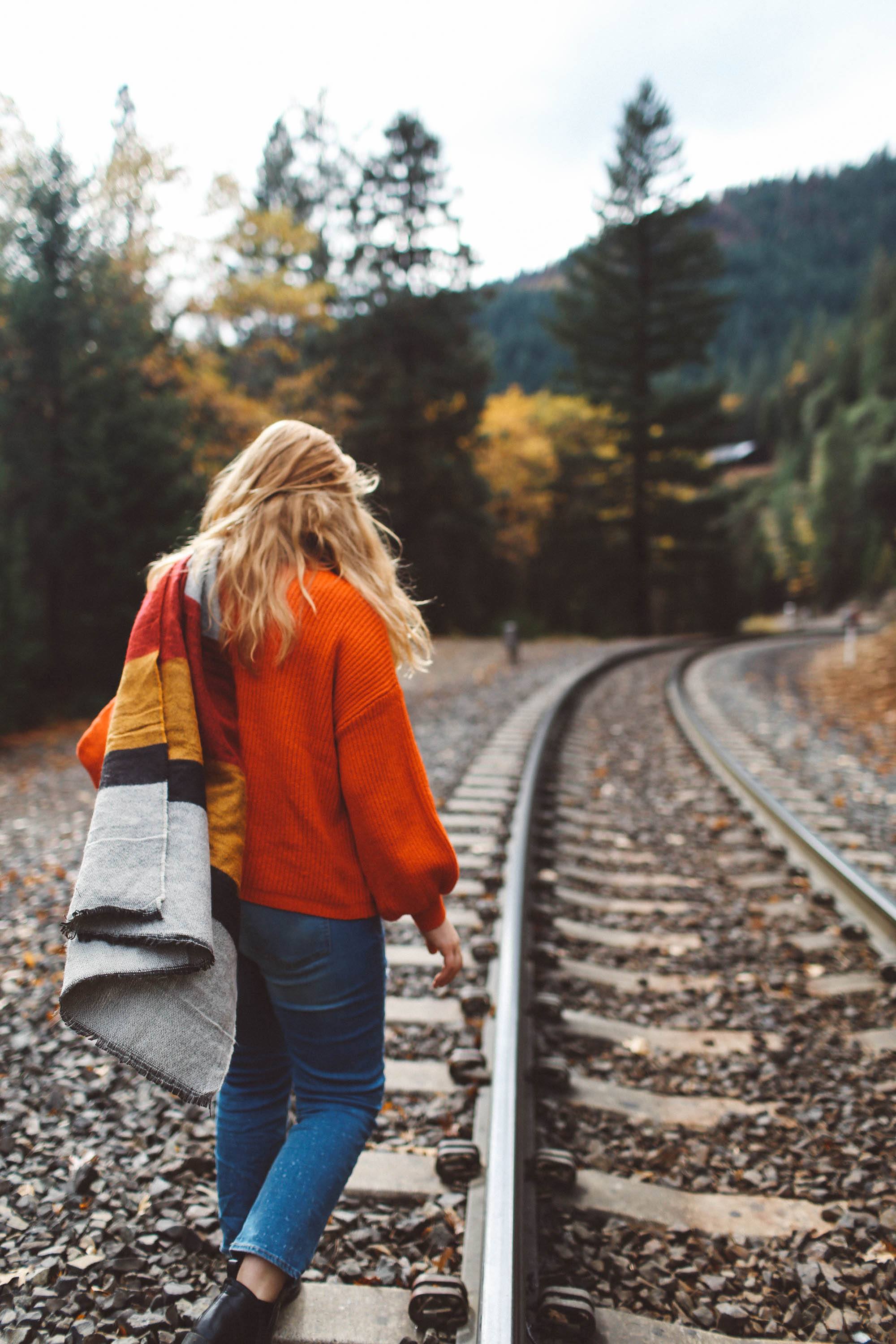 woman train tracks red sweater scarf fall