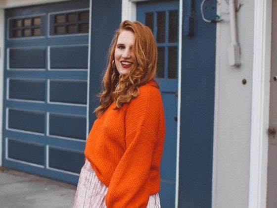 red sweater pink skirt woman red hair