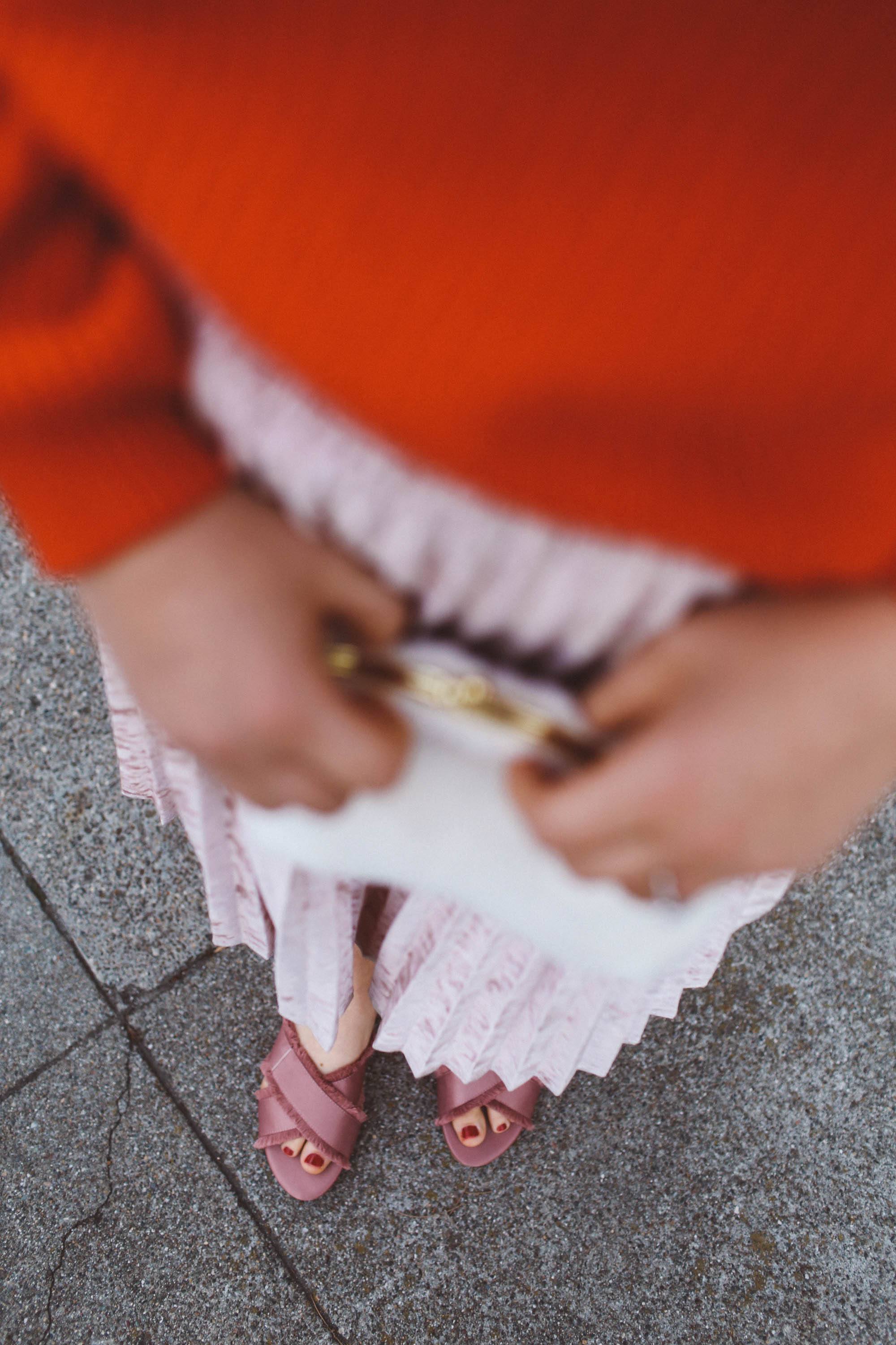 red sweater pink skirt woman white purse pink flats