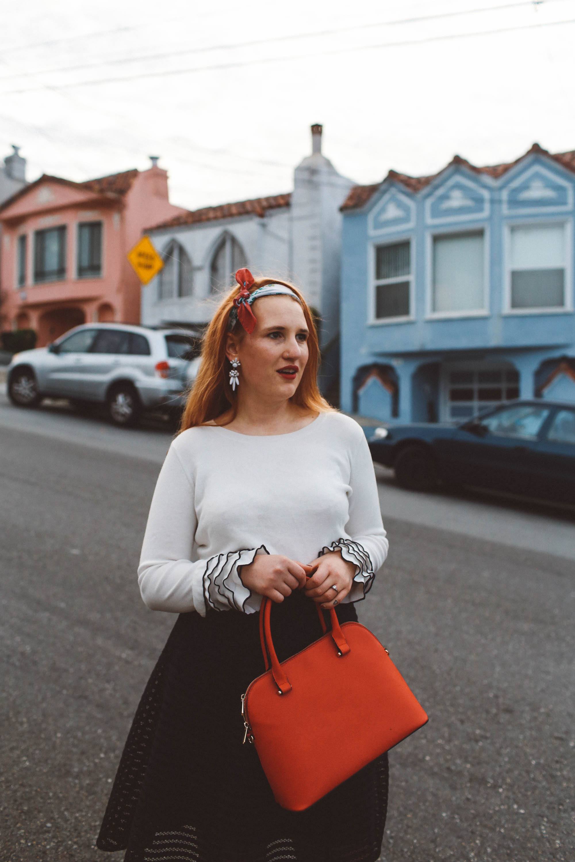 head scarf red purse black skirt ruffle sweater