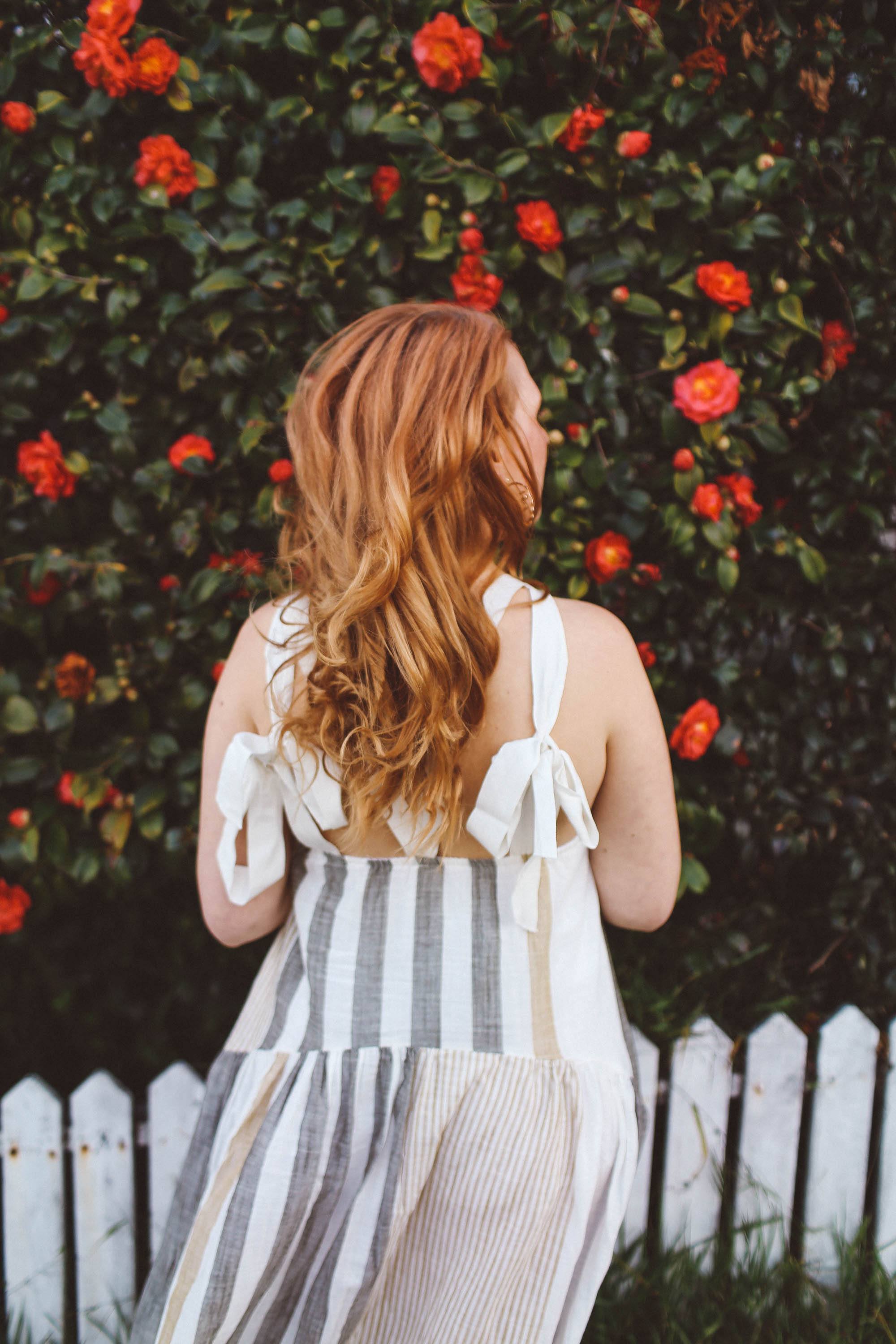 woman red hair flower wall boho dress