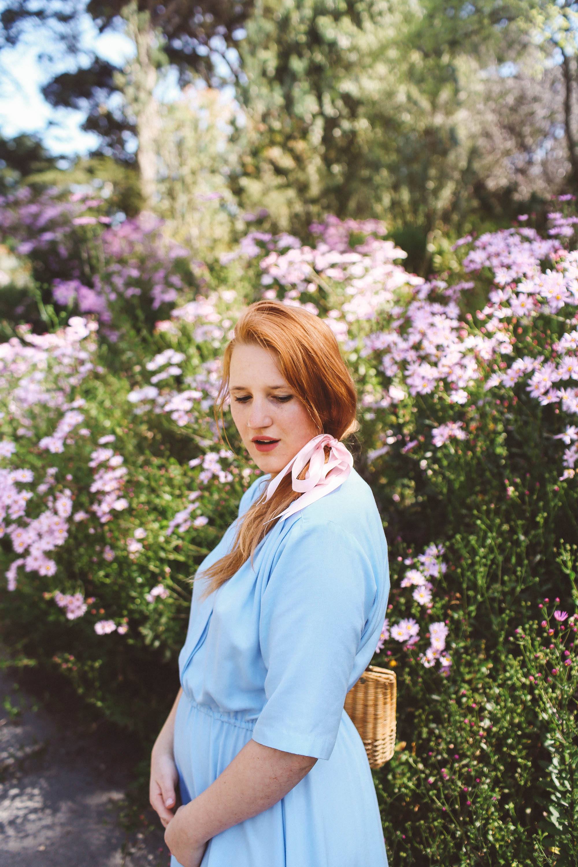 Woman in a blue vintage dress wearing a Pink headscarf