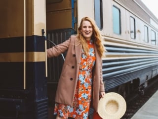 Wiman in floral dress hanging off of Napa Valley Wine Train