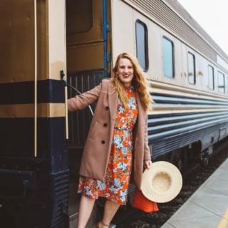 Wiman in floral dress hanging off of Napa Valley Wine Train