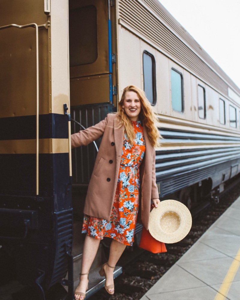 Wiman in floral dress hanging off of Napa Valley Wine Train