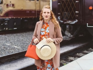 Woman in floral dress standing in front of Napa Valley Wine Train