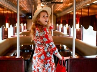 Woman in red floral dress standing in the aisle of the Napa Valley Wine Train