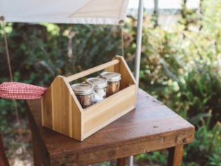 Wooden box with jars on a table on tent porch
