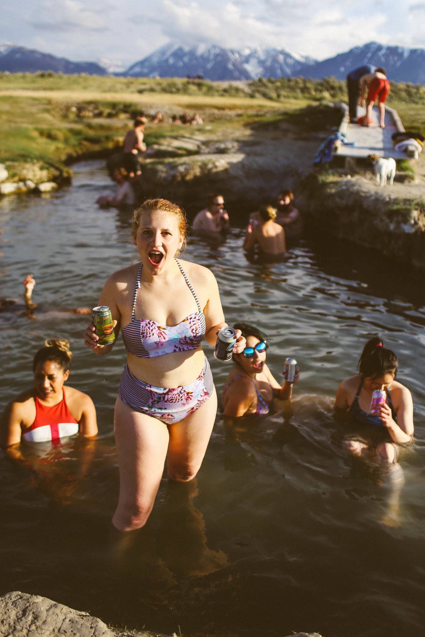 many people sitting in hot springs in the mountains