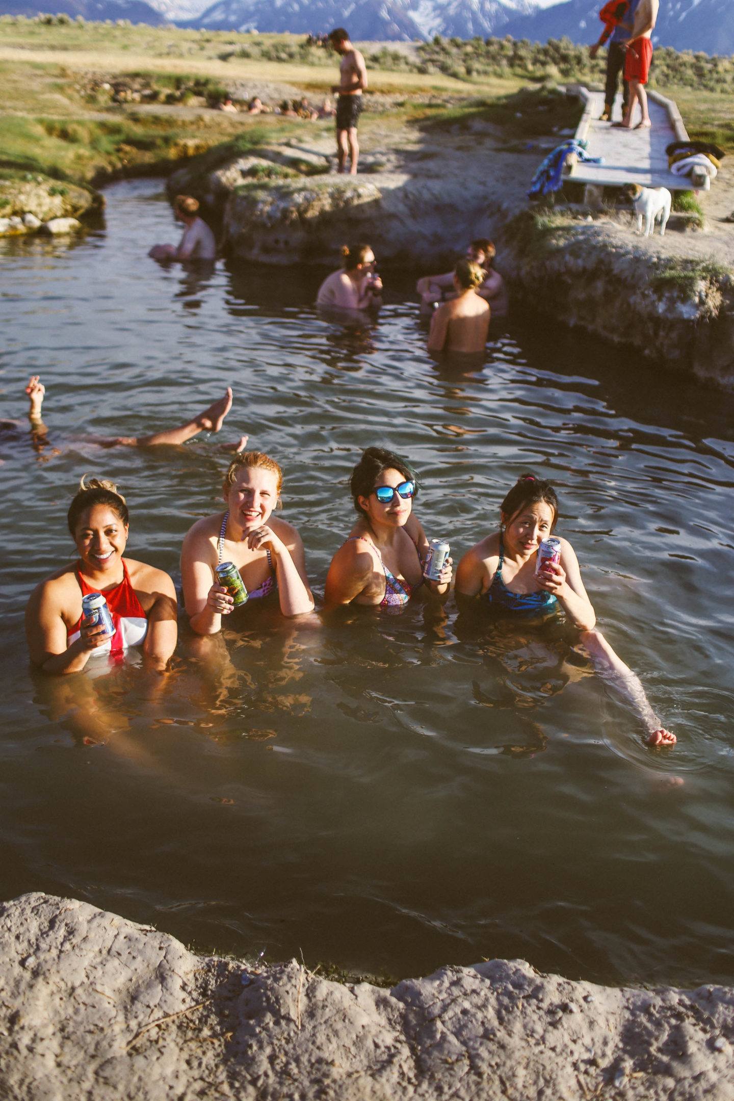 many people sitting in hot springs in the mountains