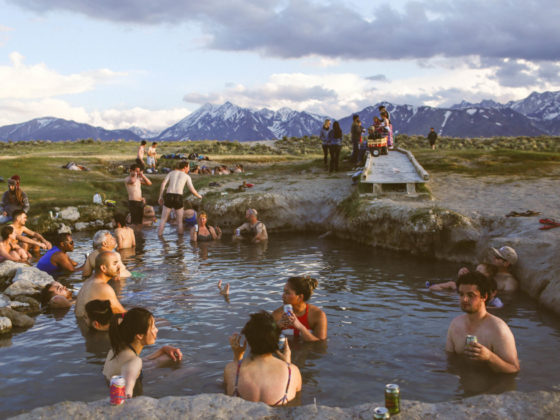 many people sitting in hot springs in the mountains