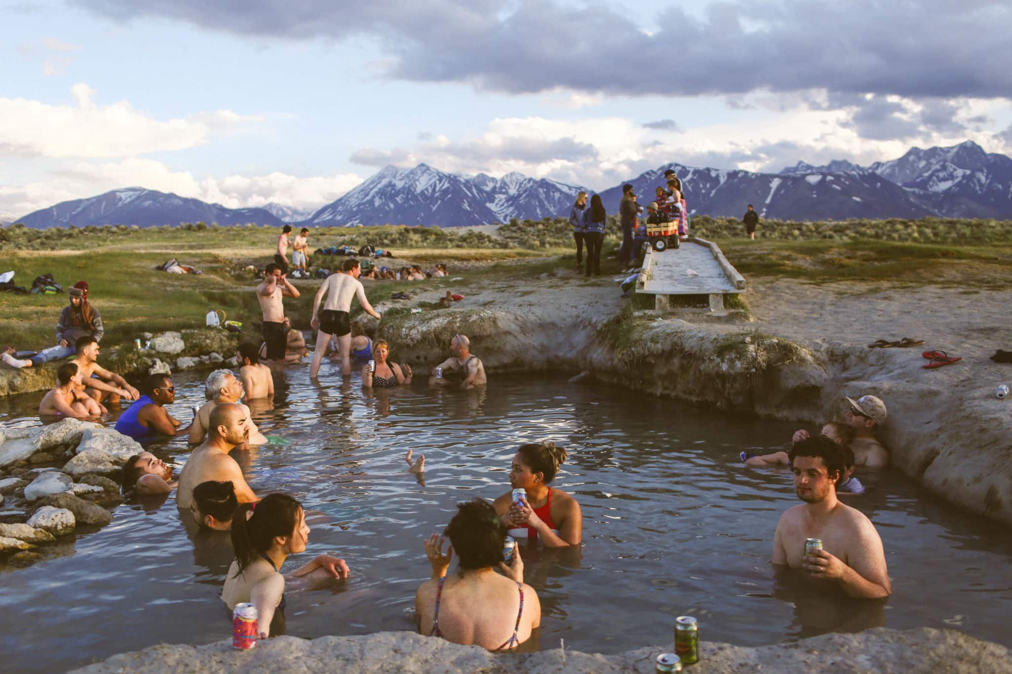 many people sitting in hot springs in the mountains