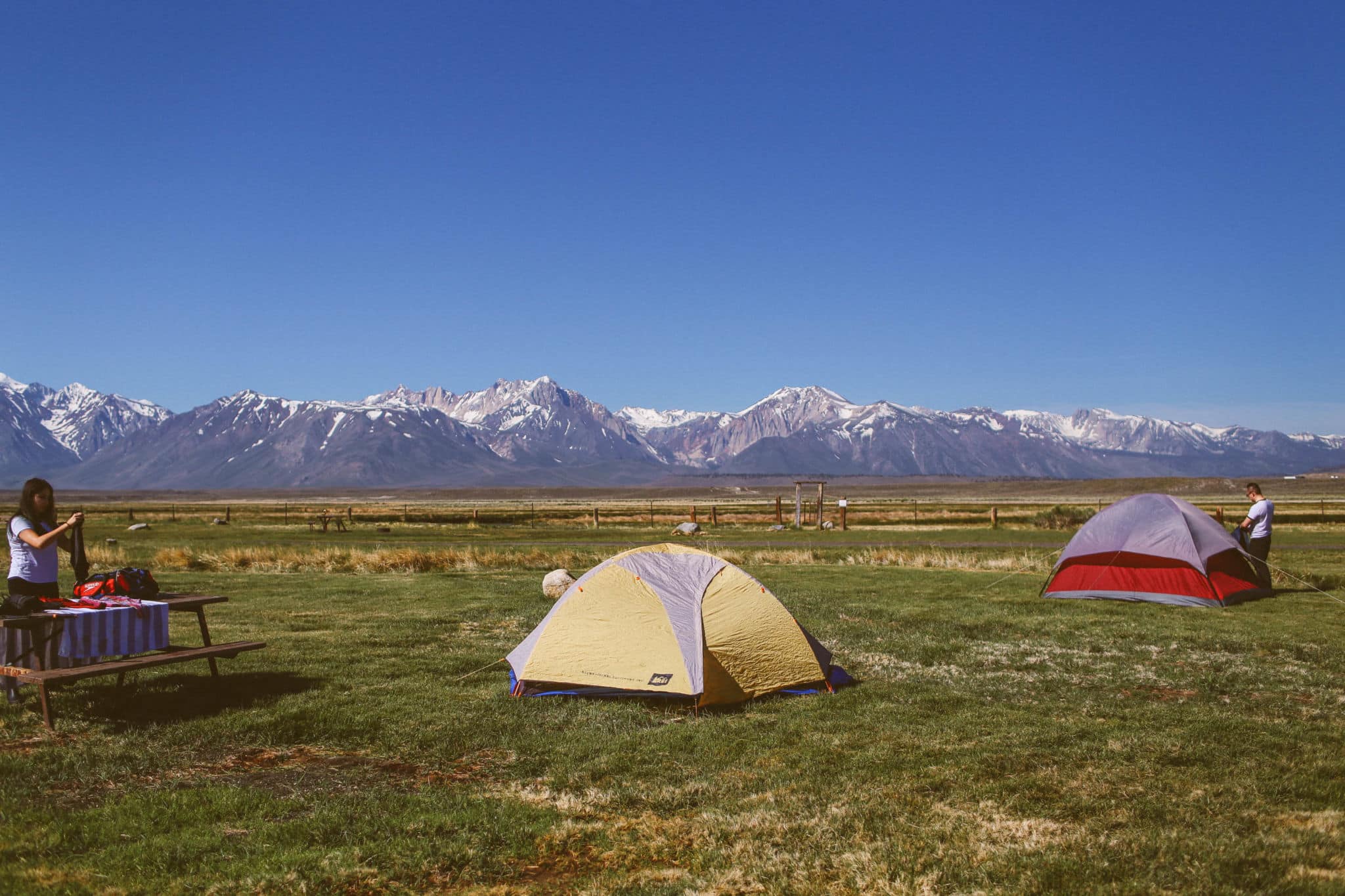 tents and people at a campground in the mountains