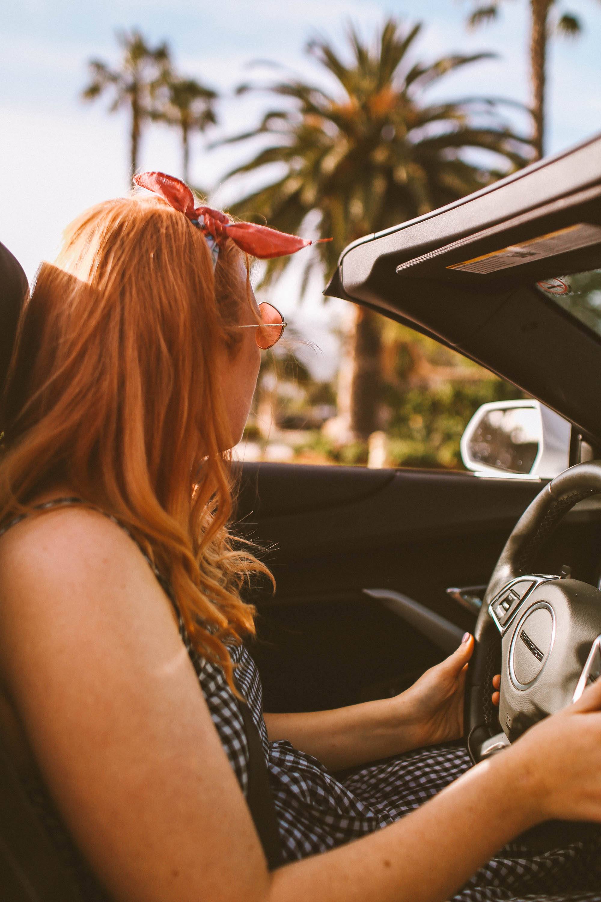 Woman in a Gingham dress driving a convertible in Santa Barbara