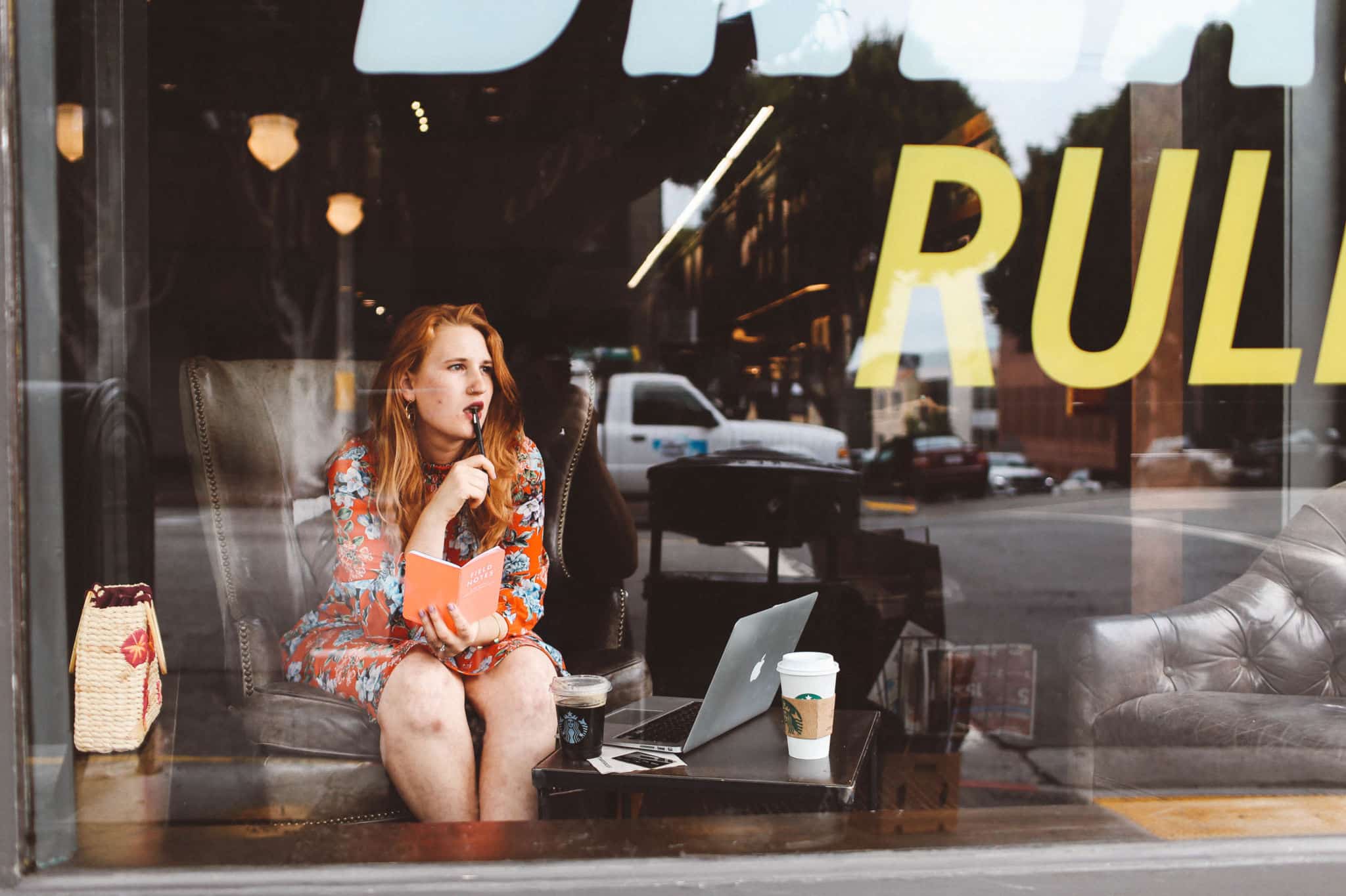 Woman in red floral dress working at Starbucks