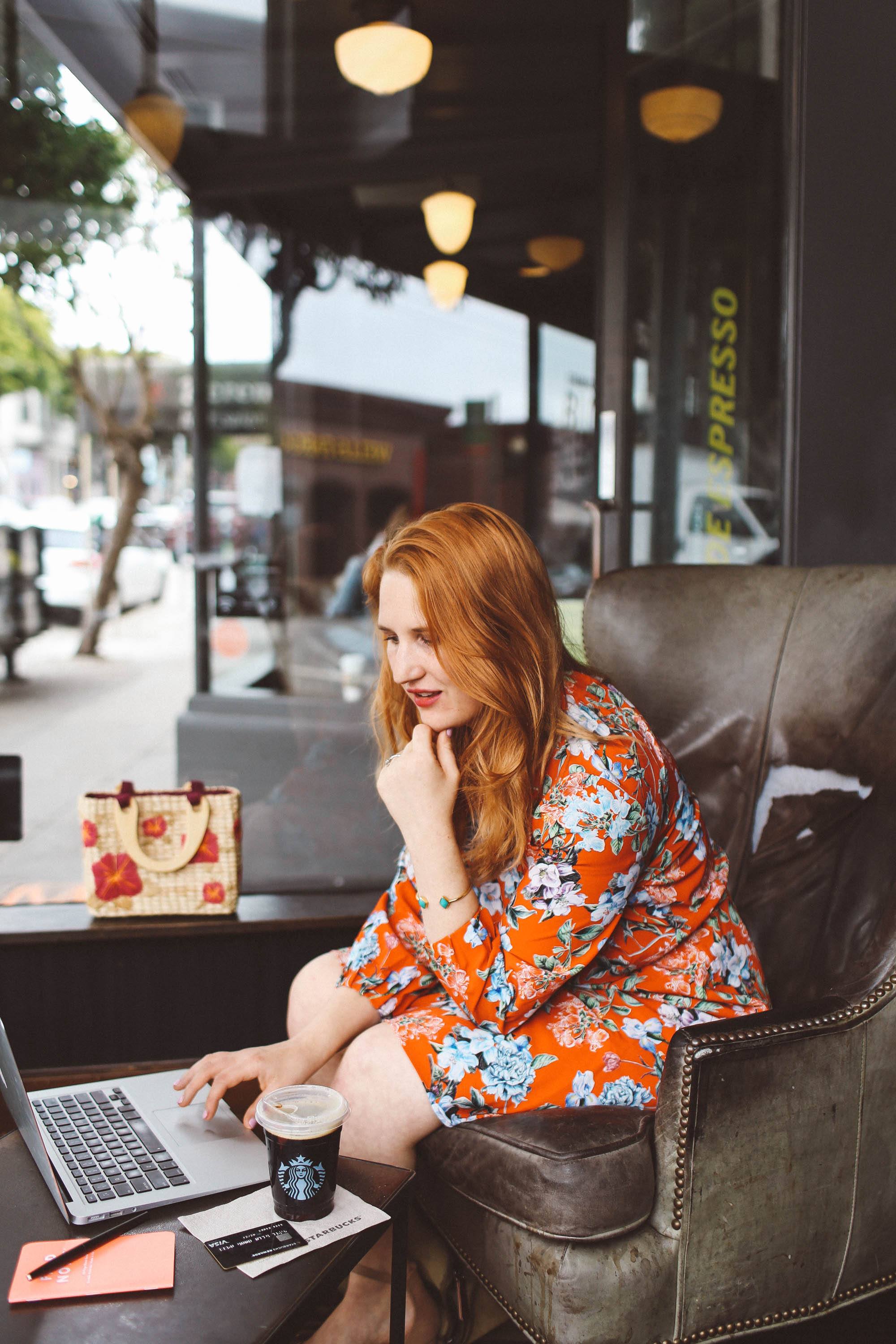 Woman in red floral dress working at Starbucks