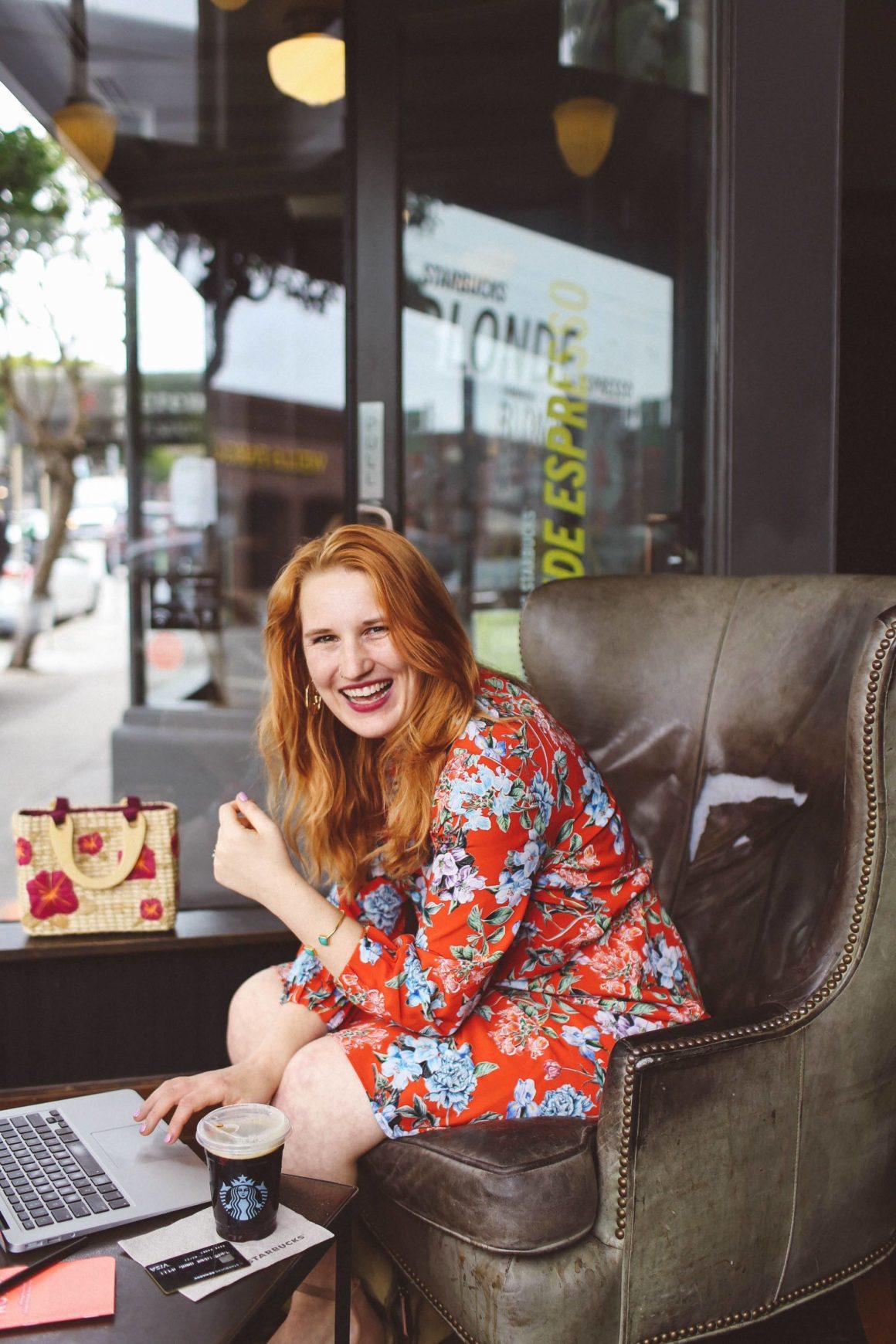 Woman in red floral dress working at Starbucks