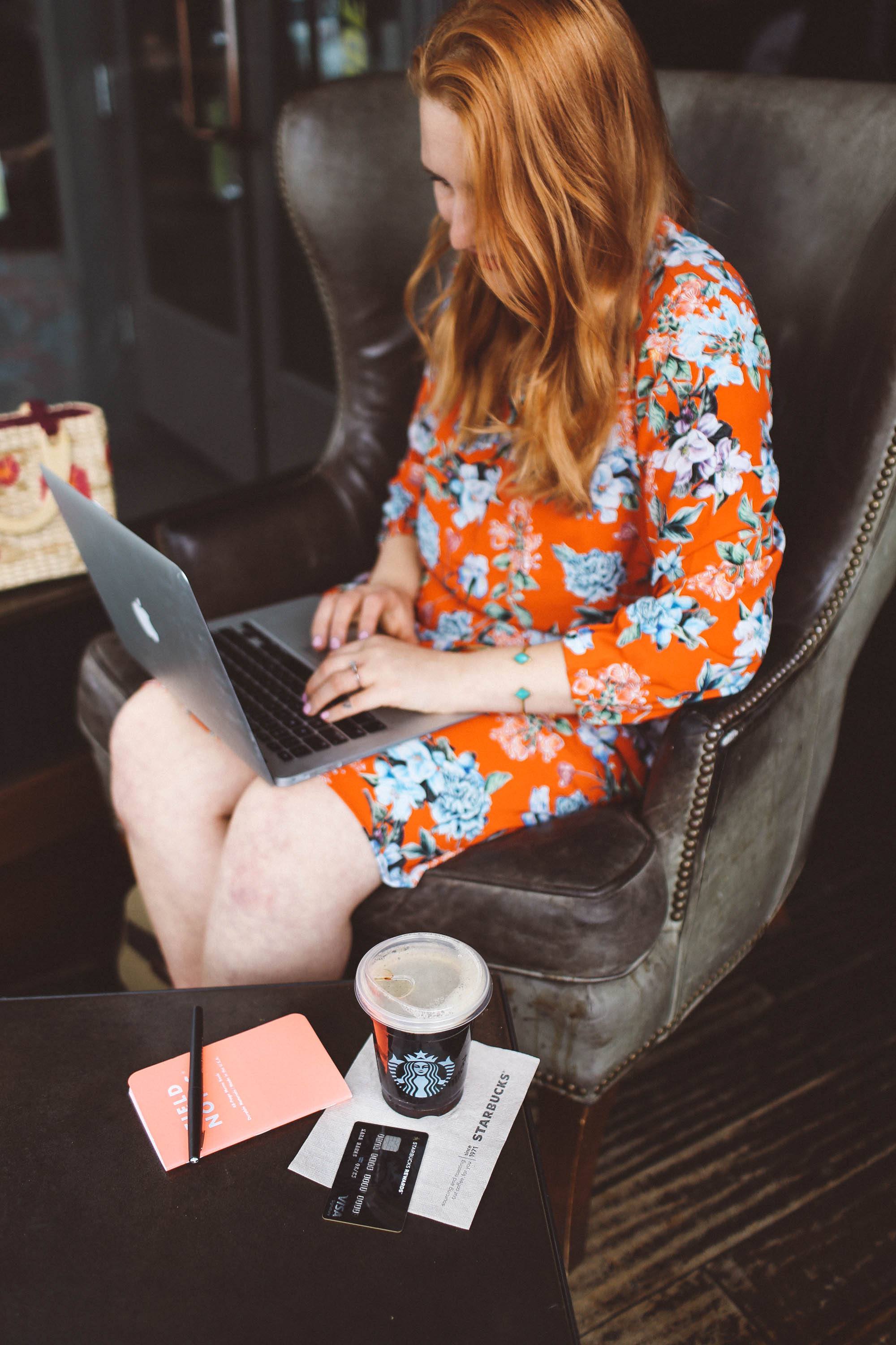 Woman in red floral dress working at Starbucks