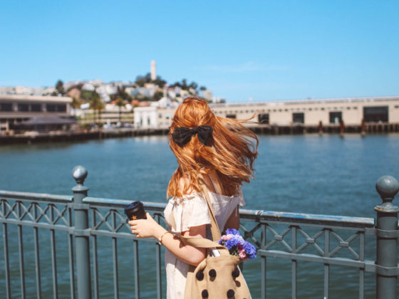 Woman holding coffee looking out over the water