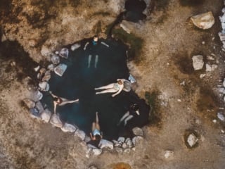 Overhead photo of people in a heart shaped hot spring