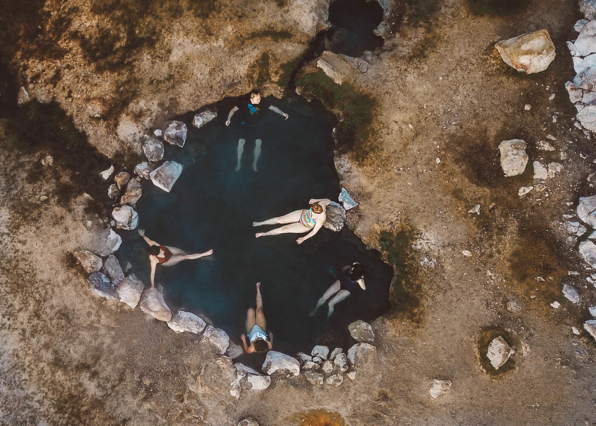 Overhead photo of people in a heart shaped hot spring