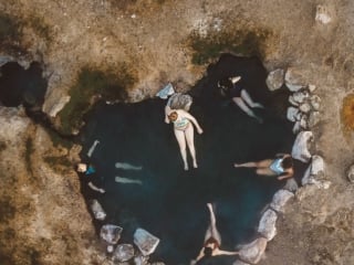 Overhead photo of people in a heart shaped hot spring