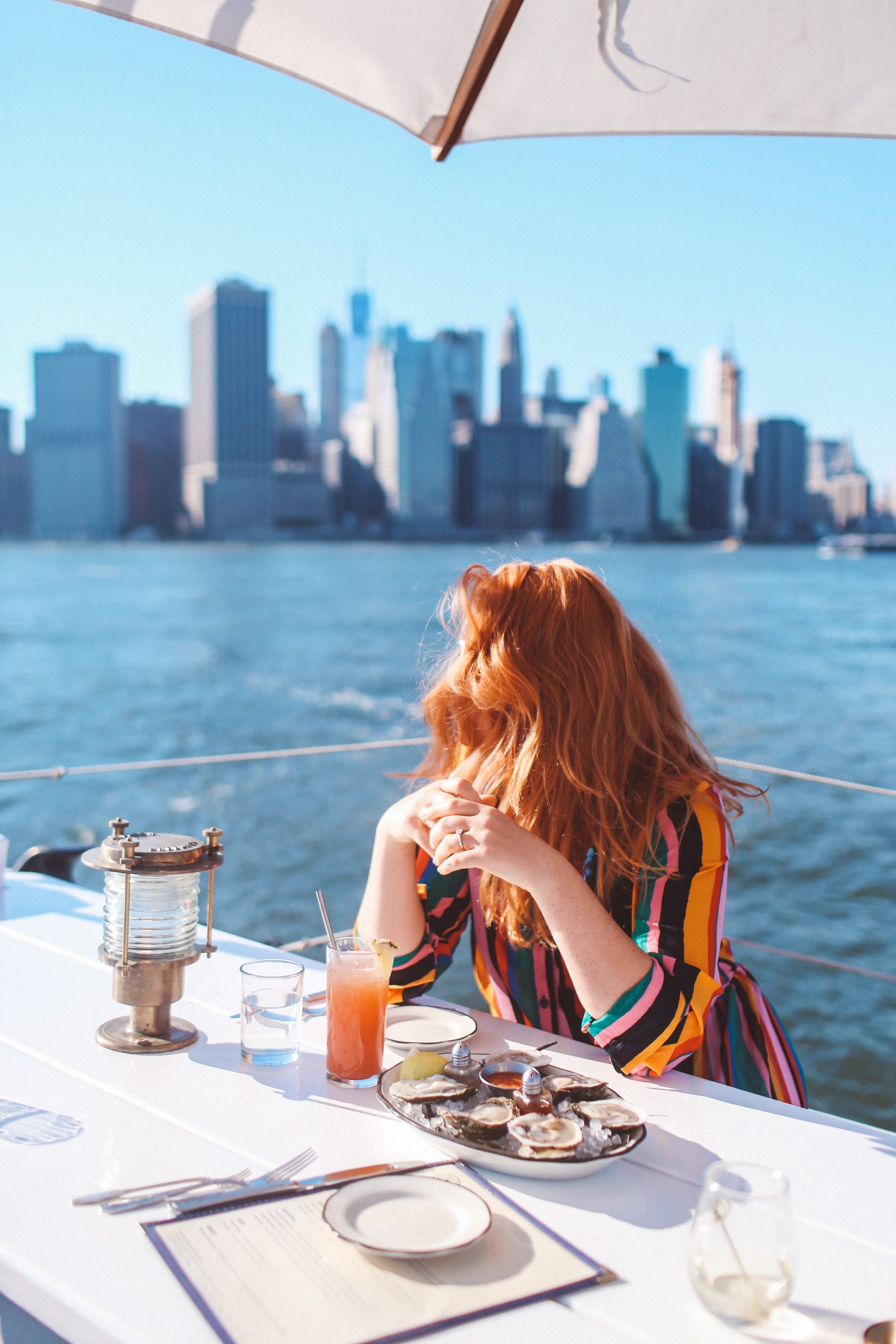 Woman in a rainbow outfit eating at a boat restaurant in Brooklyn