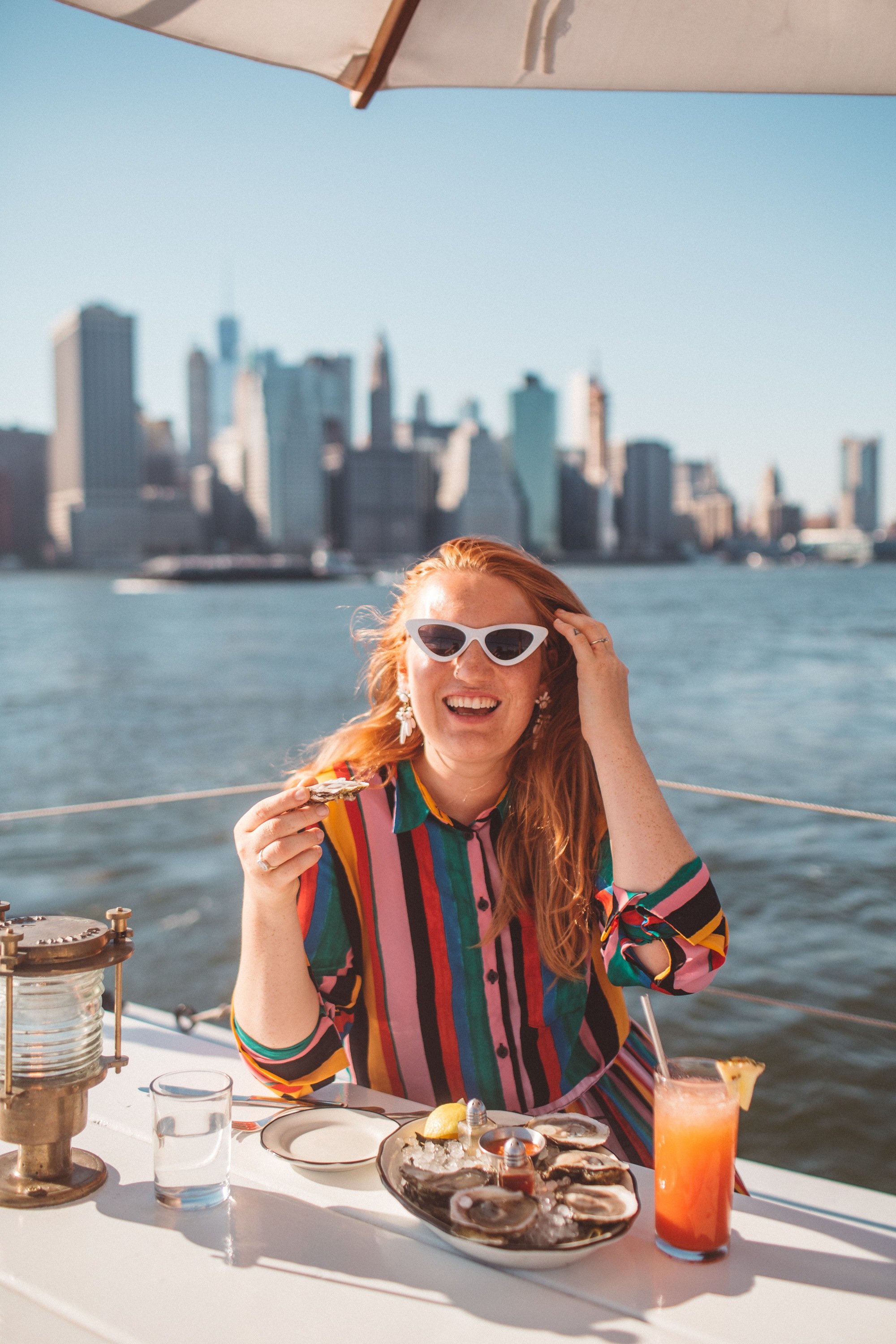 Woman in a rainbow outfit eating at a boat restaurant in Brooklyn