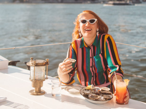 Woman in a rainbow outfit eating at a boat restaurant in Brooklyn