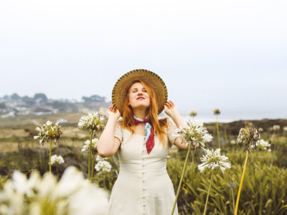 Woman in a dress and straw hat among the flowers