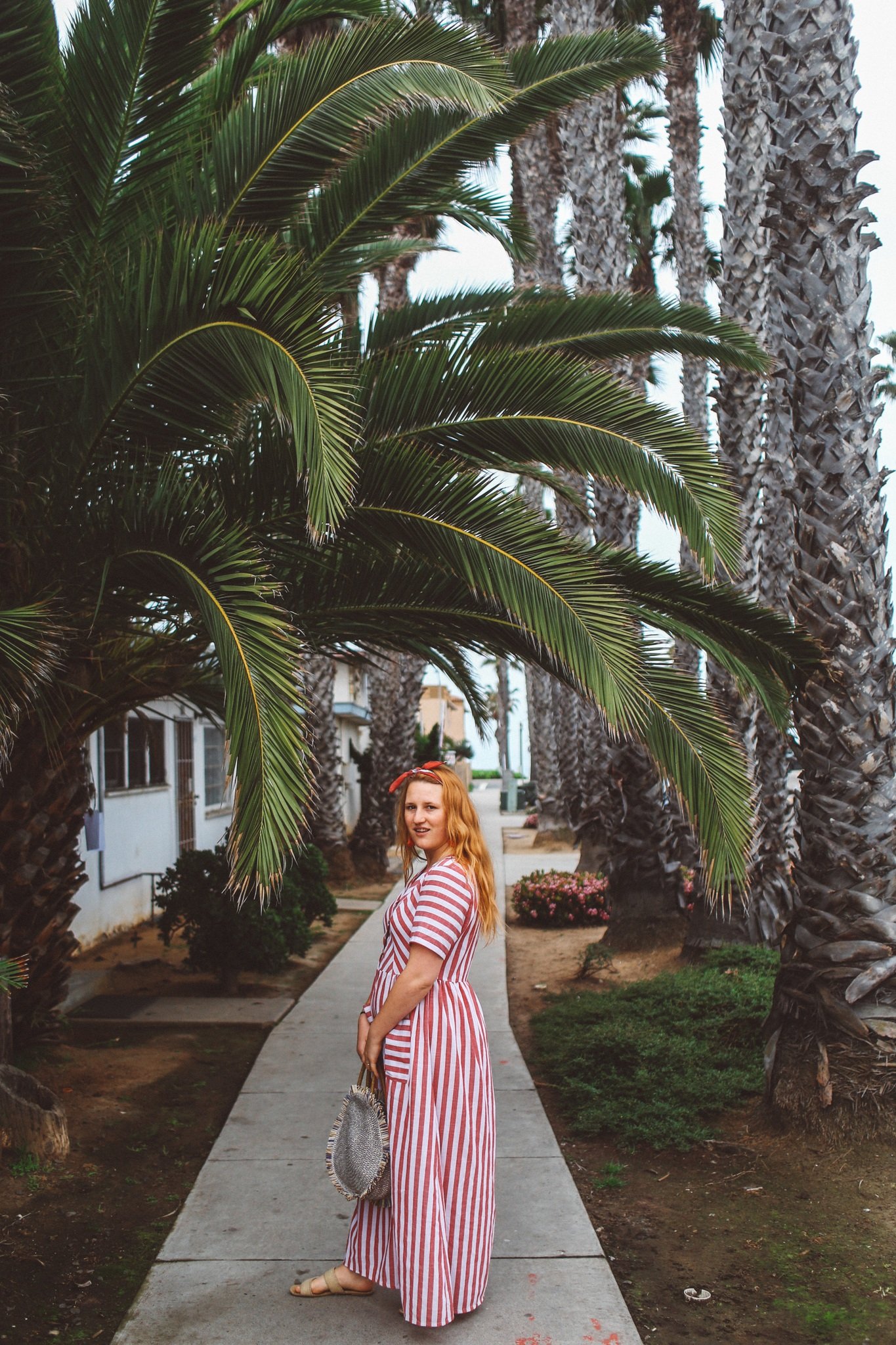 Wearing a red and white stripe dress amongst the palm trees in Oceanside, Ca