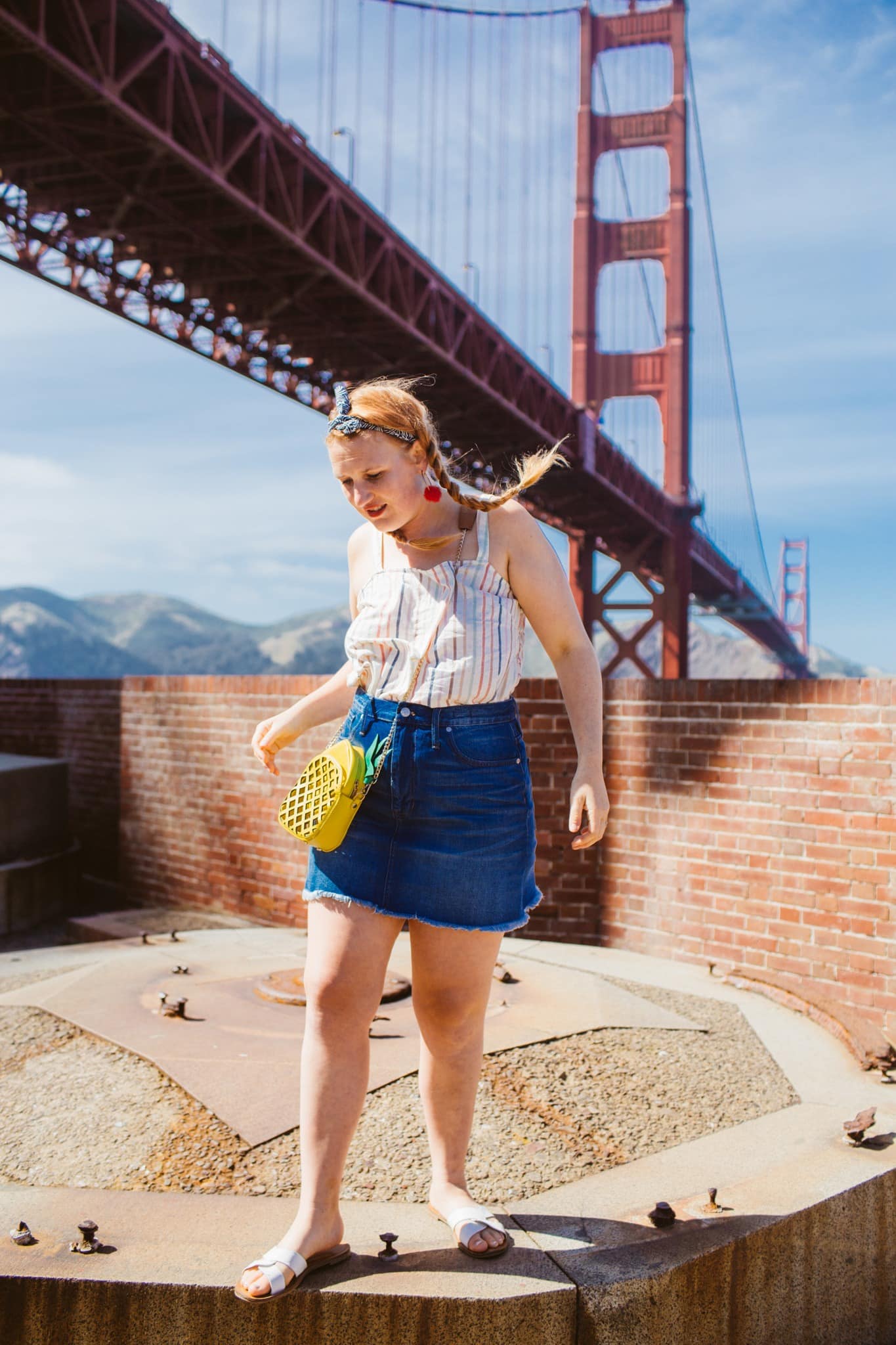 Woman in a denim skirt and a striped tank top at the Golden Gate Bridge in San Francisco