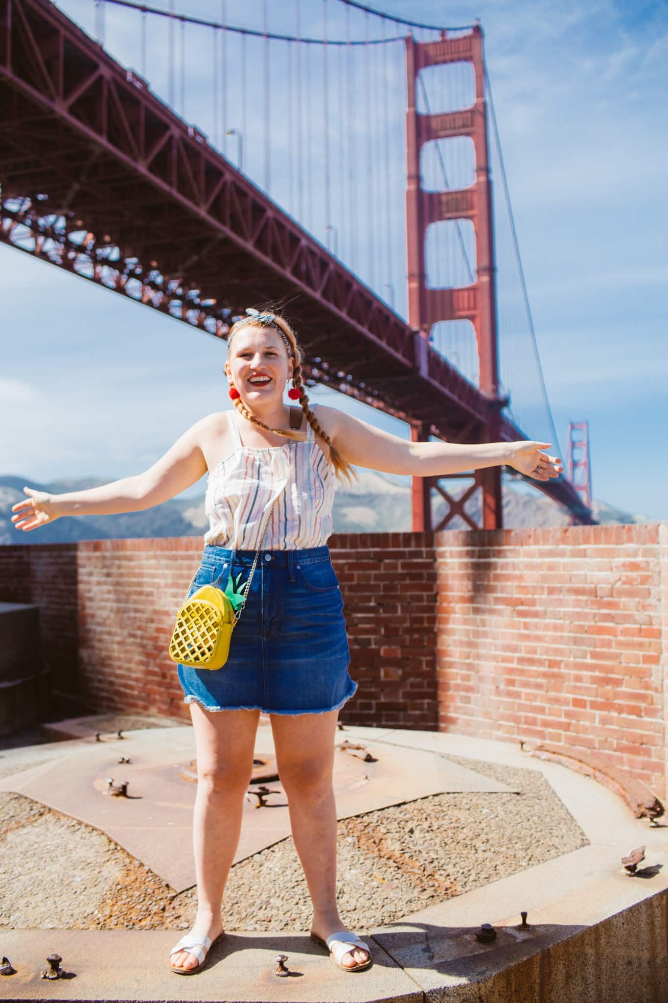 Woman in a denim skirt and a striped tank top at the Golden Gate Bridge in San Francisco